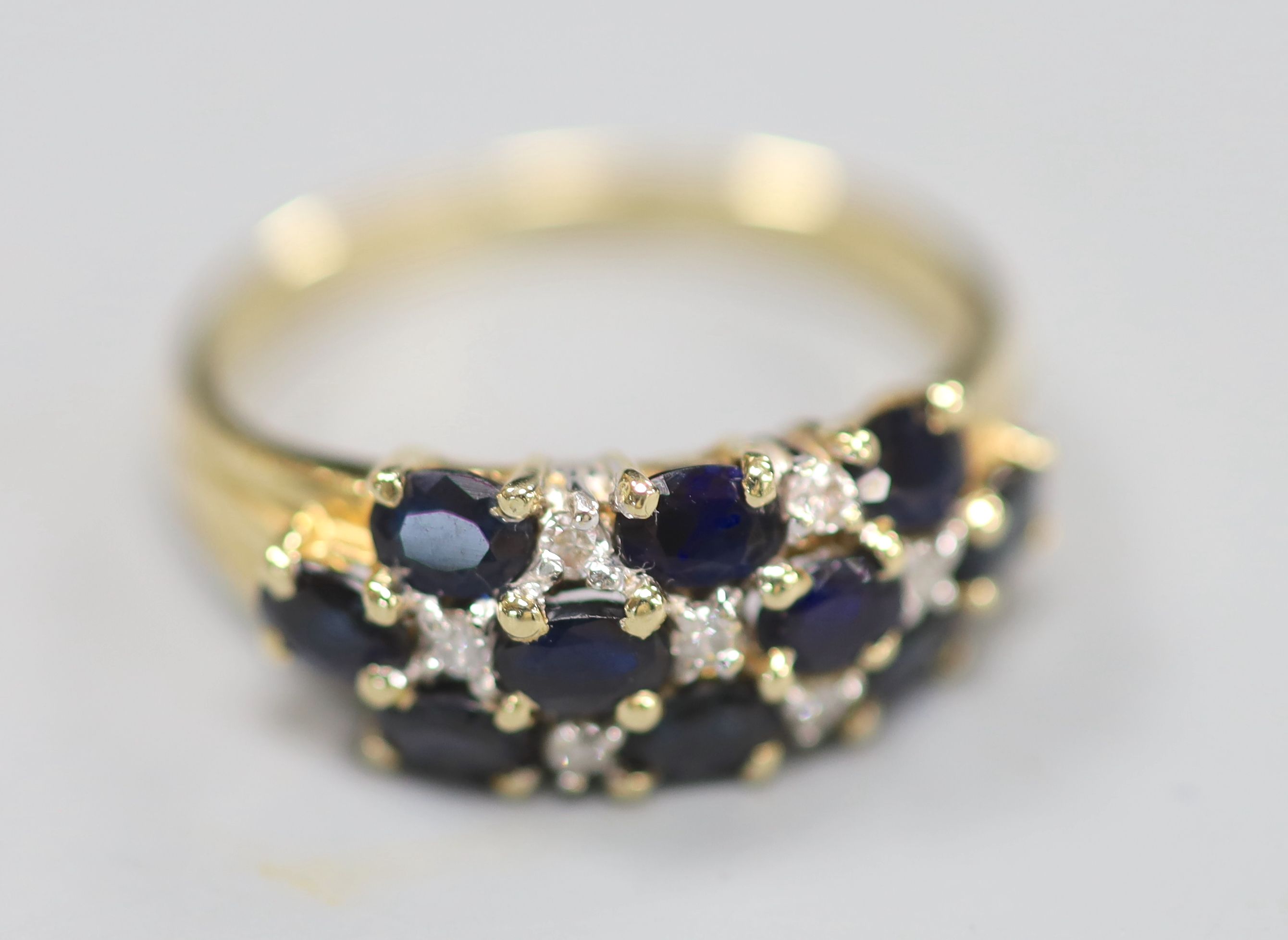 A modern 14ct gold, sapphire and diamond cluster half hoop dress ring, size Q, gross 4 grams.